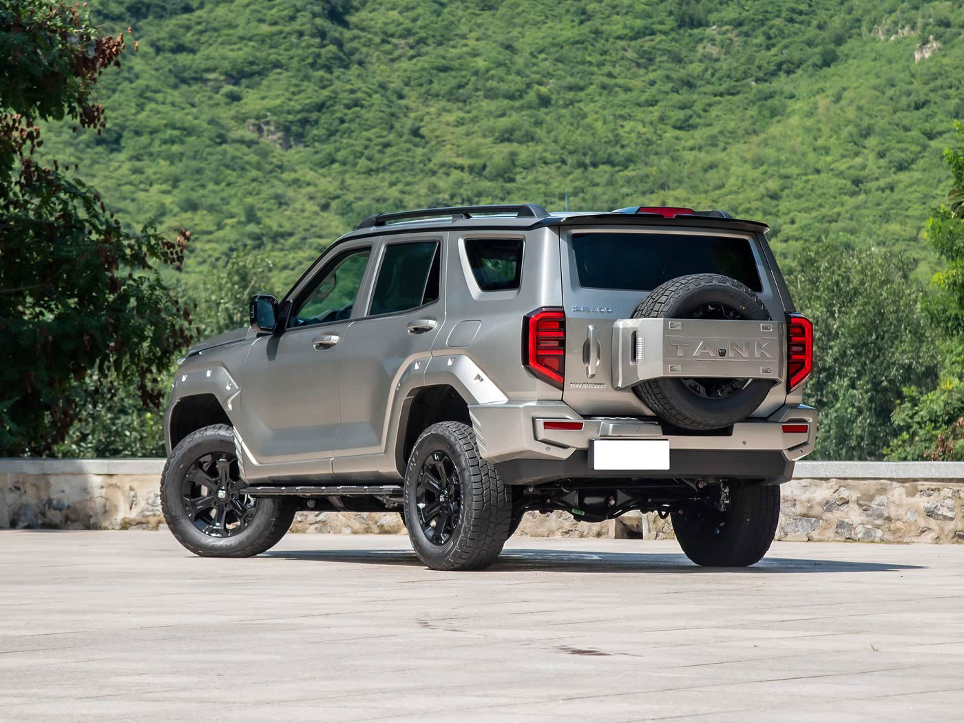 Tank 400 PHEV with spare wheel, 19-inch all-terrain tires, dusk mountain backdrop