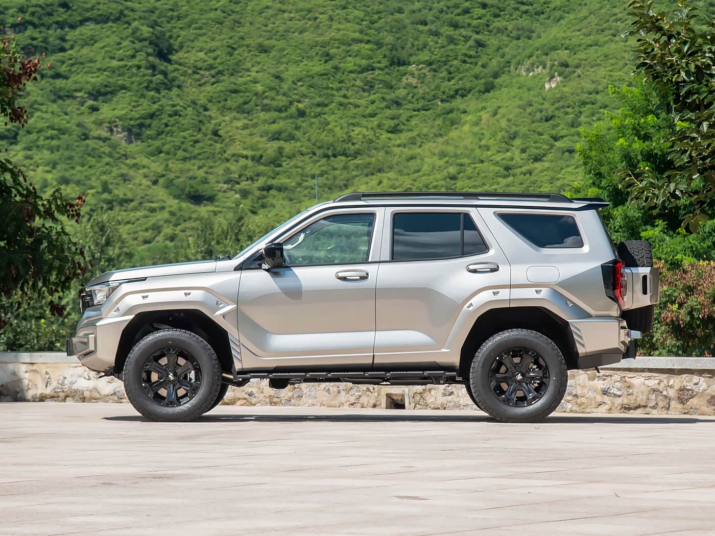 Tank 400 PHEV-Diesel SUV, 2.0 L turbodiesel + 120 kW motor, 1,000 km+ range, 19-inch AT tires, side profile on rocky trail